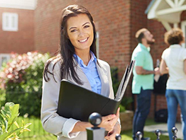 A smiling girl in coat suit holding a file in her hand, looking happy and confident